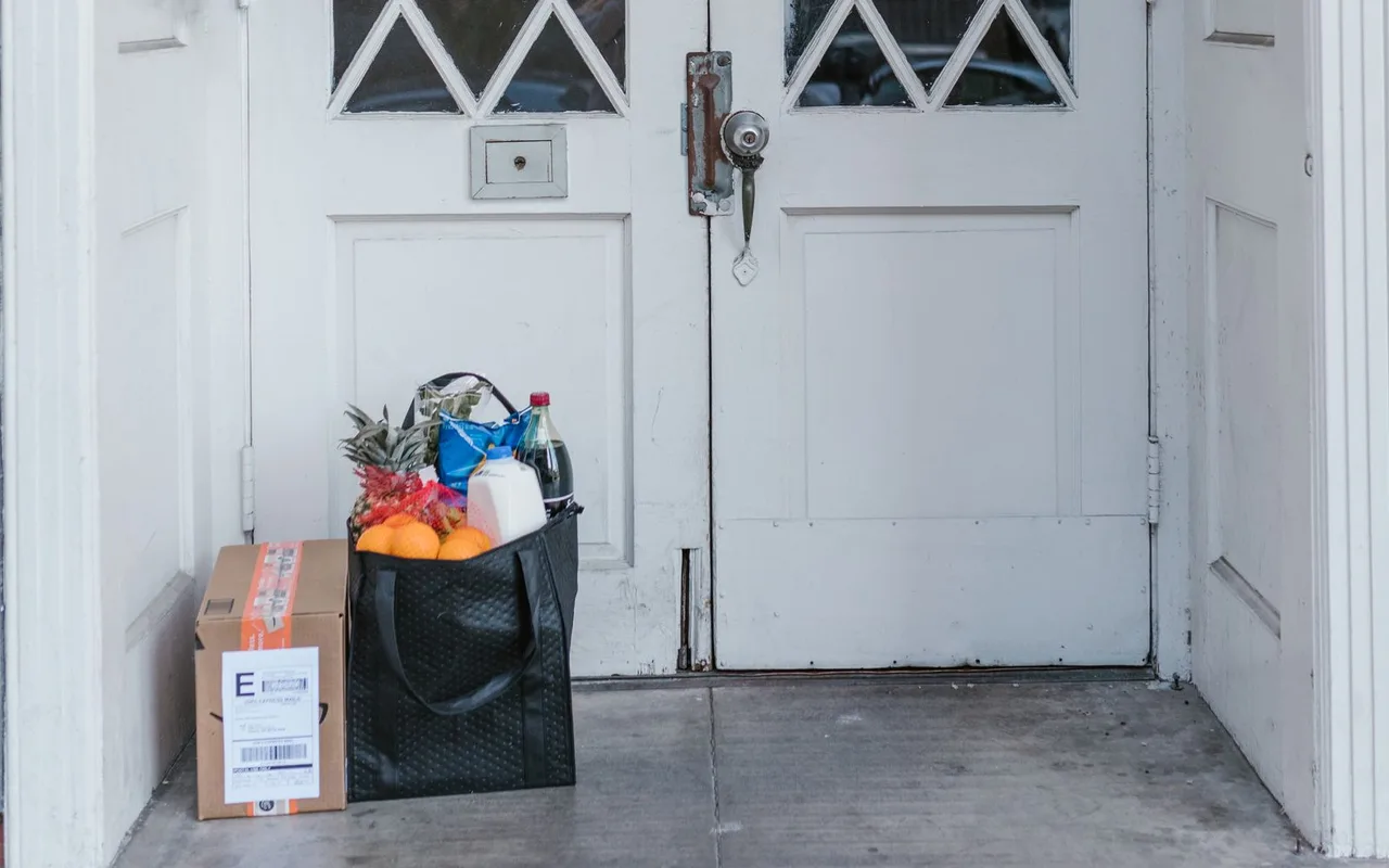 Groceries and a parcel beside a front door